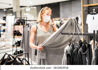 Fashionable Woman Wearing Protective Face Mask Shopping Clothes In Reopen Retail Shopping Store. New Normal Lifestyle During Corona Virus Pandemic.