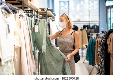 Fashionable Woman Wearing Protective Face Mask Shopping Clothes In Reopen Retail Shopping Store. New Normal Lifestyle During Corona Virus Pandemic.