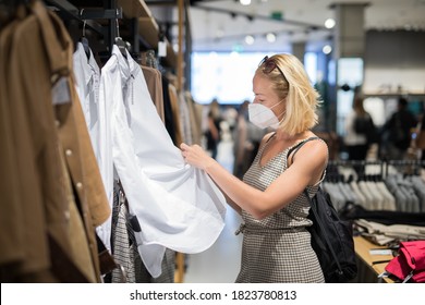 Fashionable Woman Wearing Protective Face Mask Shopping Clothes In Reopen Retail Shopping Store. New Normal Lifestyle During Corona Virus Pandemic.