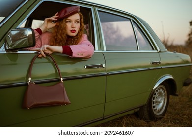 Fashionable woman wearing trendy faux leather beret, holding stylish brown bag, handbag, posing in the green retro car. Copy, empty space for text - Shutterstock ID 2092461607