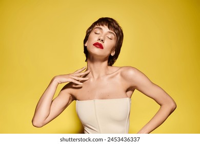 Fashionable woman in white dress, hands on hips, striking pose against vibrant backdrop. - Powered by Shutterstock