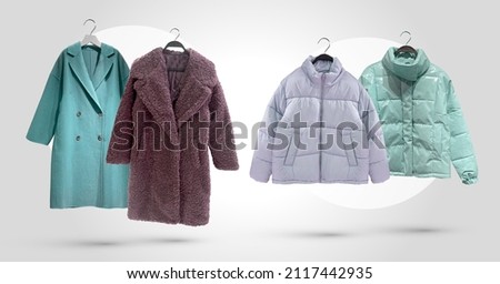 Fashionable women Faux shearling coat and down jacket. Padded coat with zip fastener isolated on blue background. Winter clothes pattern. Composition of clothes. Flat lay, top view, copy space