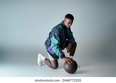 Fashionable young African American man in stylish attire crouching with basketball. - Powered by Shutterstock