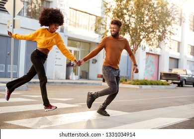 Fashionable Young Black Couple Running Across A City Street Holding Hands, Full Length, Close Up