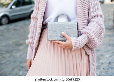 Fashionable Young Blond Woman Wearing Rose Cardigan, Beige Midi Skirt And Grey Leather Belt Bag. Street Style.