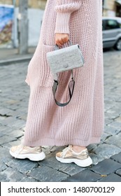 Fashionable Young Blond Woman Wearing Rose Cardigan, Beige Midi Skirt, Grey Leather Belt Bag And Golden Color Sneakers. Street Style.