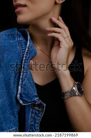 Similar – Frau mit Jeansjacke, blauer Bluse und silberner Armbanduhr.