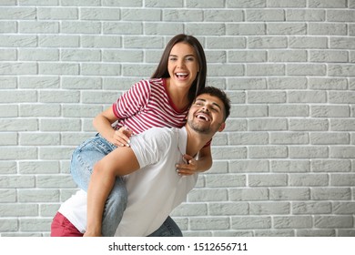 Fashionable Young Couple Against Brick Wall