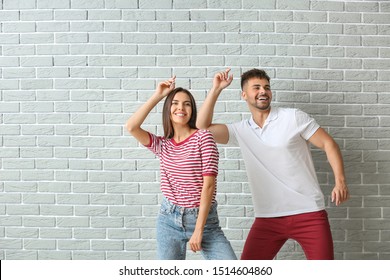 Fashionable Young Couple Against Brick Wall