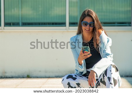 fashionable young girl with mobile phone on the street