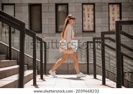 Fashionable young lady in beige in the city street