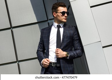 fashionable young man dressed in the gray background beautiful urban architectural form