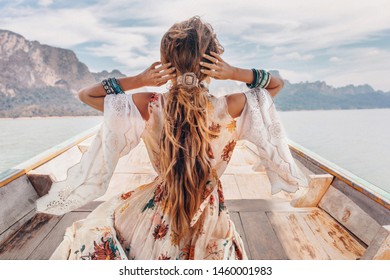 modelo jovem elegante em estilo boho vestido no barco no lago 