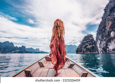 fashionable young model in boho style dress on boat at the lake 
