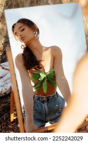 Fashionable young model in boho style clothes with mirror on a background of dry grass, field. Female beauty and style concept. Advertisement or clothes sale design. - Shutterstock ID 2252242029