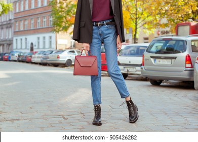 Fashionable young woman in jeans, black jacket , boots and handbag on the city streets. Fashion.Stylish .