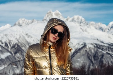 fashionable young woman on the background of mountains in winter