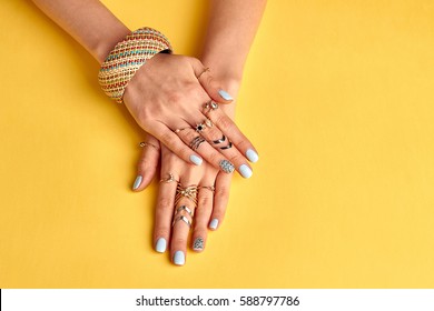 Fashionable youth bijouterie on female hands. Preparing to summer. Bijouterie and jewelry. Beautiful well-groomed female hands with nail polish.