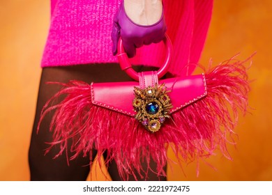 Moashionista con suéter rosado caliente, guantes de cuero con bolsa rosa con plumas de avestruz Foto de stock