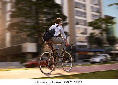 Fast, bicycle and business man in city for morning, commute and carbon neutral transportation. Travel, sustainability and cycling with male employee in urban town for motion blur, speed and transit - Shutterstock ID 2297174351
