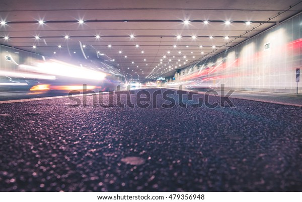 Fast cars in a modern\
tunnel by night
