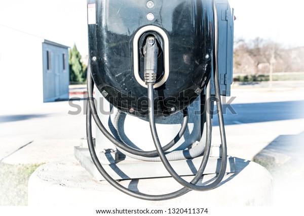 Fast\
charging electric car charging station - black charger for EV\
vehicle with charging cable and charging\
handle