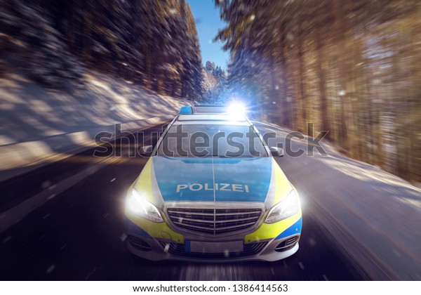 Fast driving police car in a winter forest.\
The word \