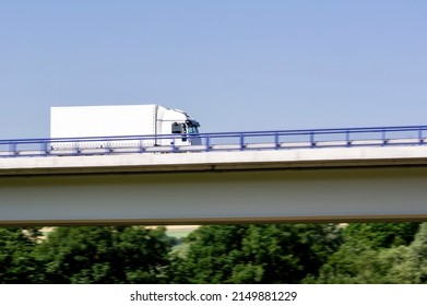 Fast Driving White Truck On A Highway Bridge