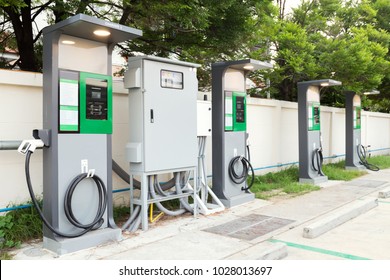 Fast Electric Vehicle Car Charger With Cable Supply Plugged And Power Supply Box At EV Station Sites. EV Car Charging Station In Car Park At Supermarket Ready To Serve Future Automotive And City Life.