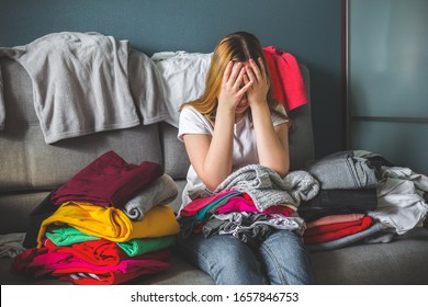 Fast Fashion, The Girl Puts Things In Order In The Closet. A Bunch Of Colorful Clothes. The Concept Of Processing, Second Hand, Eco, Minimalism, Consumption Of Goods.