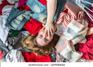 Fast fashion, the girl puts things in order in the closet. A bunch of colorful clothes. The concept of processing, second hand, eco, minimalism, consumption of goods.