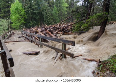 fast flooding and logs and debris against pedestrian bridge