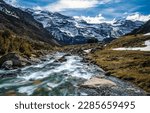Fast flowing mountain river landscape. Snowy mountain river landscape. Mountain river in winter time. River in snowy mountains