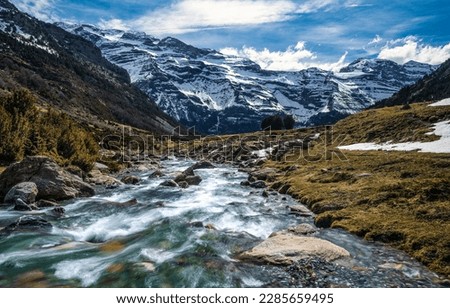 Fast flowing mountain river landscape. Snowy mountain river landscape. Mountain river in winter time. River in snowy mountains