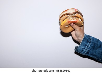 Fast Food Burger Holding In Hand On White Background. Junk Food Concept In Lifestyle Of People
