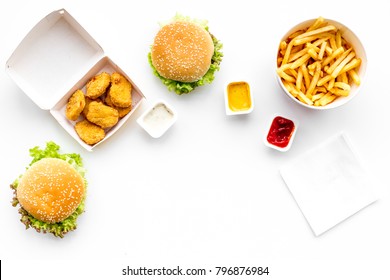 Fast Food. Chiken Nuggets, Burgers And French Fries On White Background Top View Space For Text