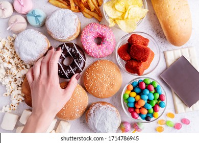 Fast food concept. Unhealthy food. Unhealthy food and fast food with donuts, chocolate, burgers and sweets top view