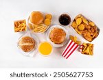 Fast food delivery menu background with various burgers, cheeseburger, nuggets, french fries, fizzy soda drinks. Junk unhealthy fast food, Ultra processed food with low nutrition, high calories value