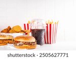 Fast food delivery menu background with various burgers, cheeseburger, nuggets, french fries, fizzy soda drinks. Junk unhealthy fast food, Ultra processed food with low nutrition, high calories value