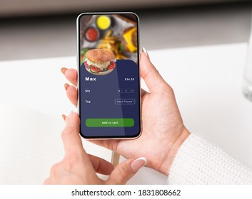 Fast Food Delivery To Work In Office Or Home During Pandemic. Hands Of Business Woman Holding Smartphone With Application For Ordering Eat, Burger In Online Menu On Screen, Pov, Close Up, Free Space