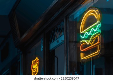 Fast food establishment by night with a hamburger neon sign