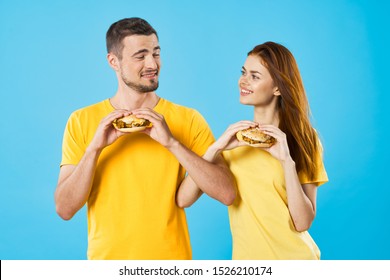 Fast food hamburger man yellow tank top woman red hair blue background - Powered by Shutterstock