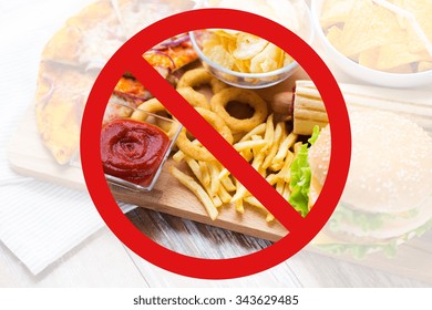 Fast Food, Low Carb Diet, Fattening And Unhealthy Eating Concept - Close Up Of Deep-fried Squid Rings, French Fries And Other Snacks Behind No Symbol Or Circle-backslash Prohibition Sign