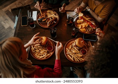 Fast food, lunch or dinner on the table at restaurant, people eating for nutrition and wellness with time together - Powered by Shutterstock