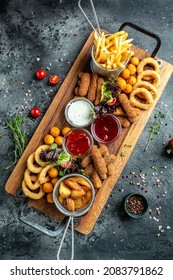 Fast Food Meals Mozzarella Sticks, Onion Rings, French Fries, Chicken Nuggets And Sauce. Pub Appetizers On A Wooden Board. Banner, Menu