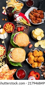 Fast food and unhealthy eating concept - close up of fast food snacks and cola drink on a dark background, top view. - Shutterstock ID 2179468499