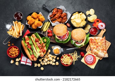 Fast food and unhealthy eating concept - close up of fast food snacks and cola drink on a dark background, top view. - Powered by Shutterstock