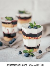 Fast Homemade Dessert With Sour Cream,chopped Cookies And Blackberry Made In Glasses On White Background.Sweet Dessert Is Decorated With Some Blackberries And Mint Leaves.High Quality Photo