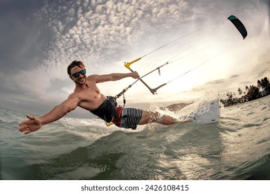 Fast kite surfer rides at sunset sea beach. Close up photo with hand and kite in sky - Powered by Shutterstock