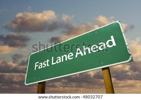 Fast Lane Ahead Green Road Sign Over Dramatic Clouds and Sky.